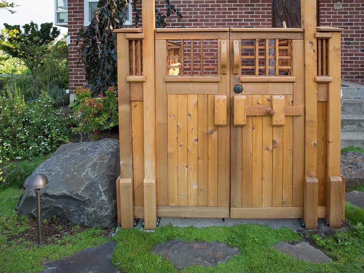 Wooden garden gate with brick background