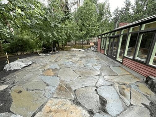 Spacious stone patio with greenery surroundings